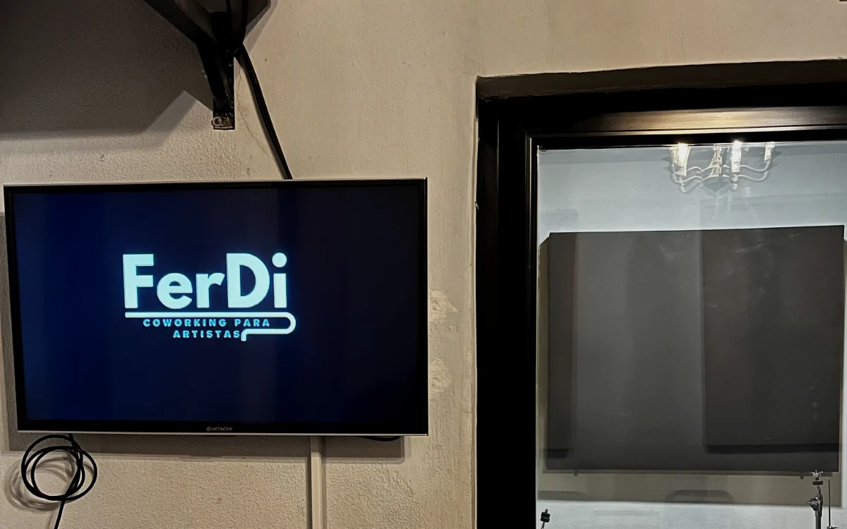 Pantalla con logo FerDi y vista hacia la sala de ensayo